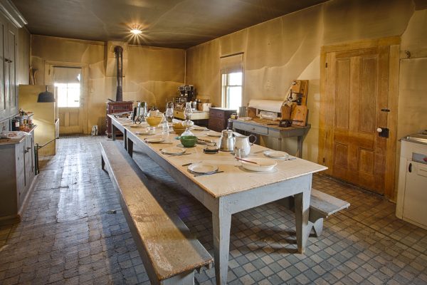 dangberg home ranch historic park Old-fashioned kitchen with a long table, benches, and dishes set for a meal; worn, vintage decor.